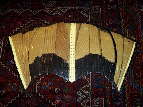 Unpainted inside of panels of cardboard corset.